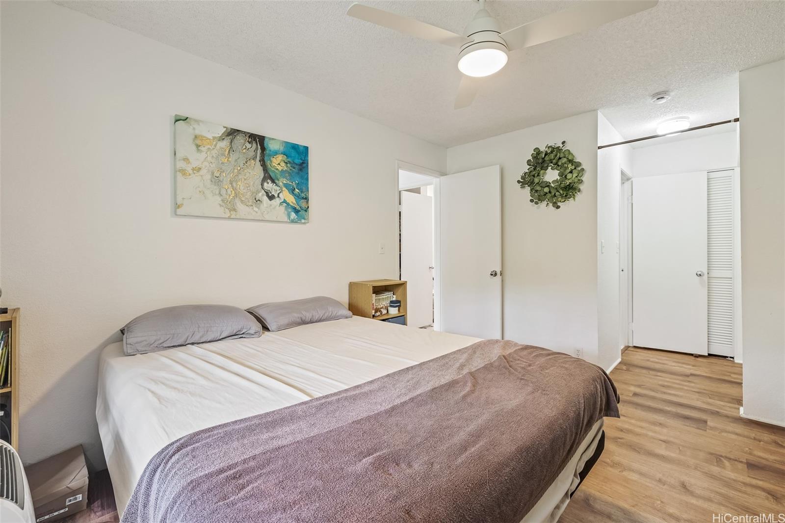 509 Mananai Place, Unit 33T Honolulu, HI 96818 - Photo 12 of 22 a bedroom with a large bed and a chandelier