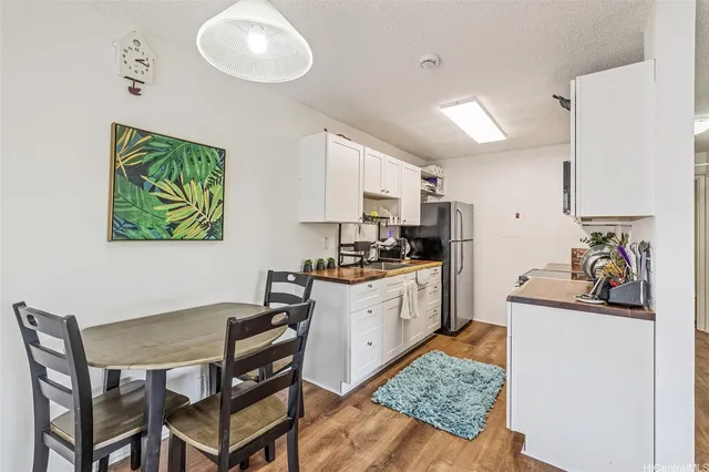 a kitchen with a dining table cabinets and appliances