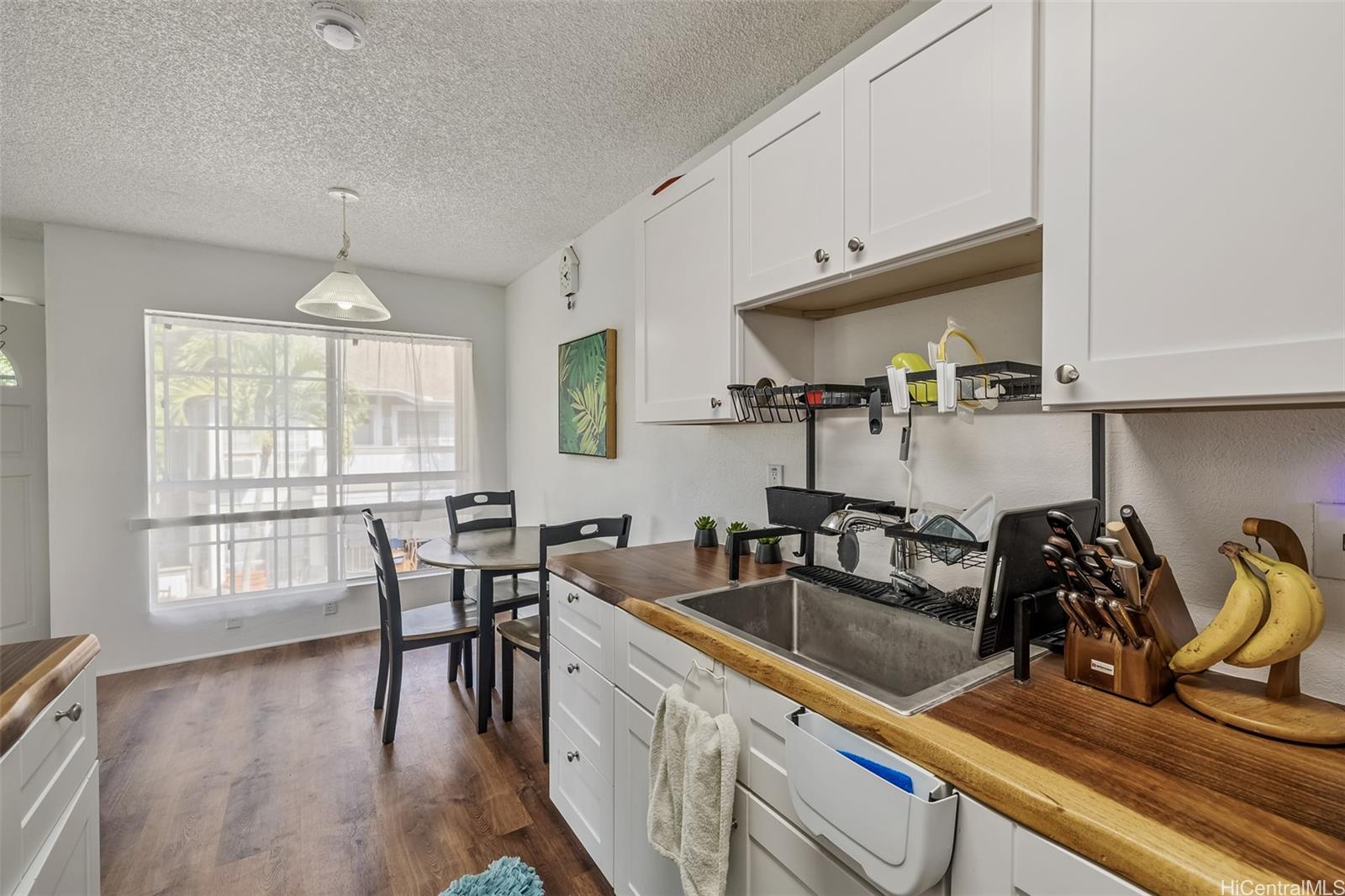 509 Mananai Place, Unit 33T Honolulu, HI 96818 - Photo 8 of 22 a kitchen that has a table chairs in it and wooden floors