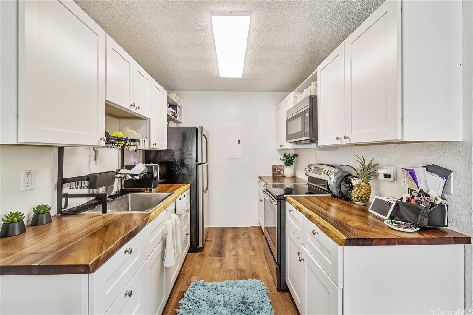 509 Mananai Place, Unit 33T Honolulu, HI 96818 - Photo 9 of 22 a kitchen with stainless steel appliances granite countertop a sink stove refrigerator and cabinets