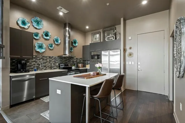 a kitchen with stainless steel appliances a sink and a refrigerator