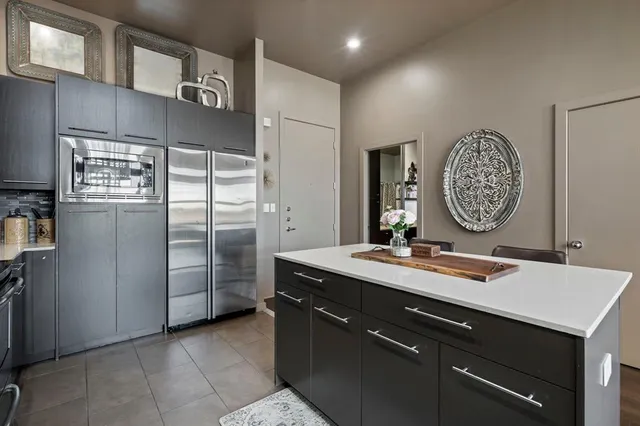 a kitchen with kitchen island granite countertop a sink a refrigerator and a refrigerator