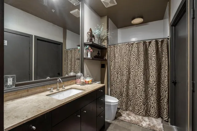 a bathroom with a granite countertop sink toilet and shower