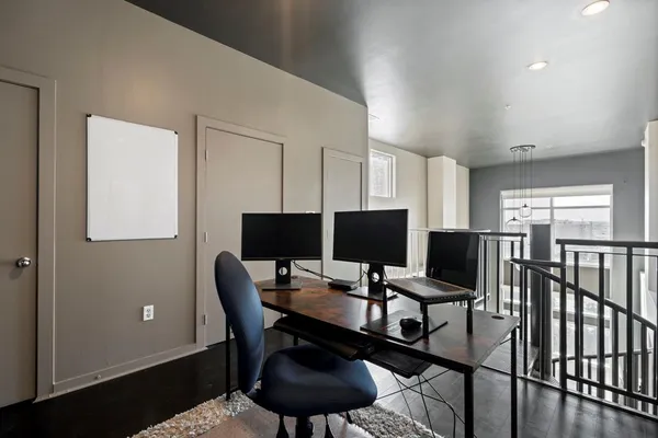 a view of a workspace with furniture and a window