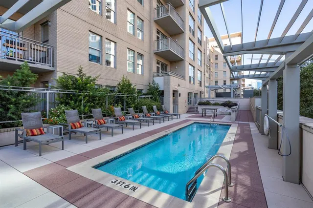 a view of a swimming pool with a couches chairs and wooden floor