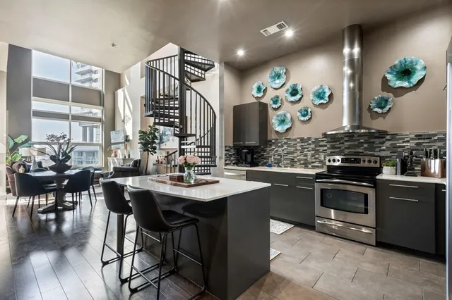 a kitchen with stainless steel appliances granite countertop a sink stove and cabinets