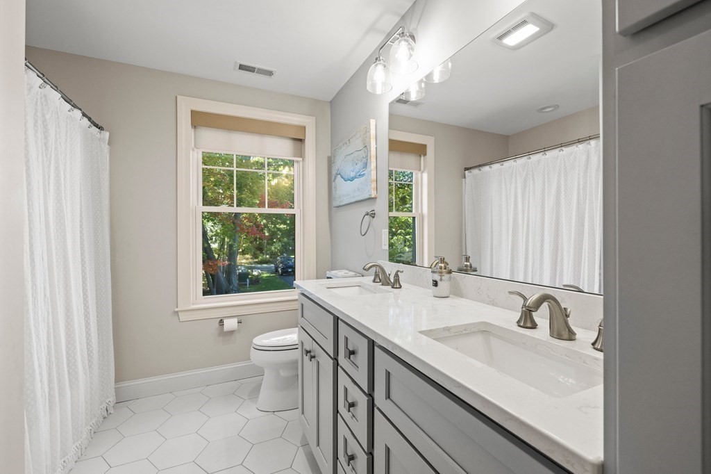 12 Big Rock Road Rye, NH 03870 - Photo 29 of 42 a bathroom with a double vanity sink toilet and a mirror
