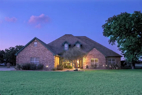 a view of a big house with a big yard and large trees
