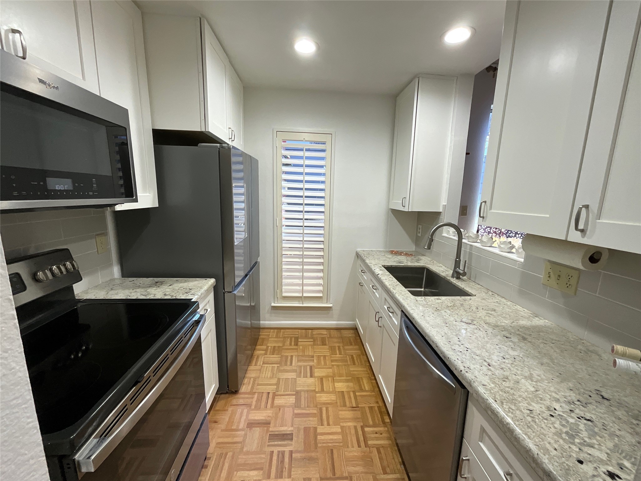 2100 Commonwealth Street, Unit L Houston, TX 77006 - Photo 6 of 30 a kitchen with granite countertop stainless steel appliances a sink stove top oven and cabinets