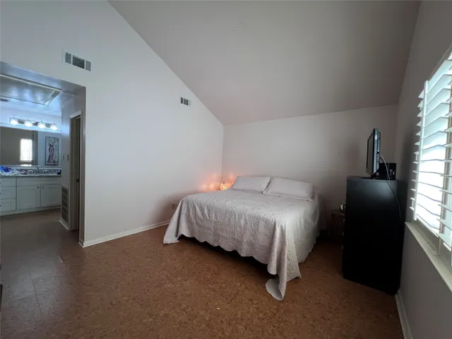 a bedroom with a bed and a view of kitchen