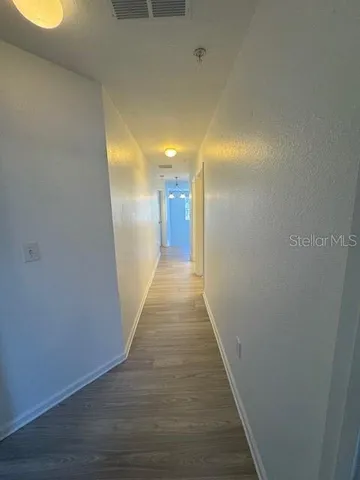 a view of a hallway with wooden floor