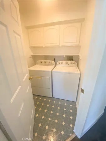 a view of washer and dryer with kitchen in the background