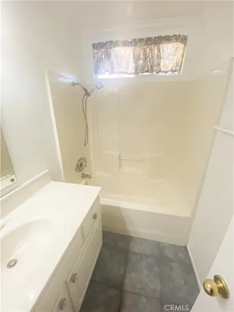 a bathroom with a tub sink and mirror
