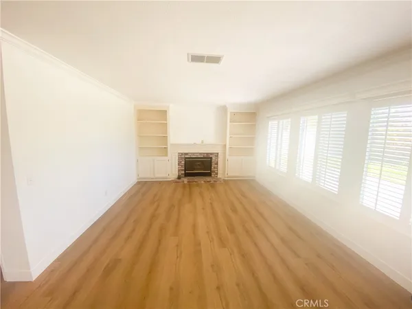 a view of a room with wooden floor and furniture