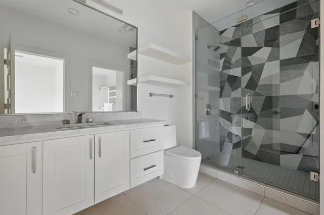 a bathroom with a double vanity sink a toilet and a mirror