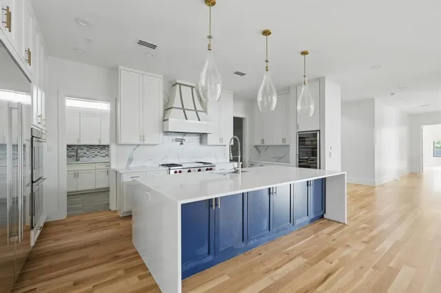a kitchen with white cabinets sink and stainless steel appliances