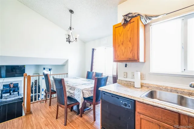 a kitchen with stainless steel appliances granite countertop a table chairs in it and a window
