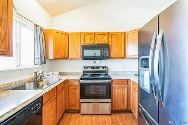 a kitchen with stainless steel appliances granite countertop a stove a refrigerator and a sink
