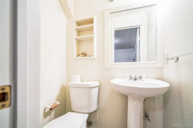 a bathroom with a sink toilet and mirror