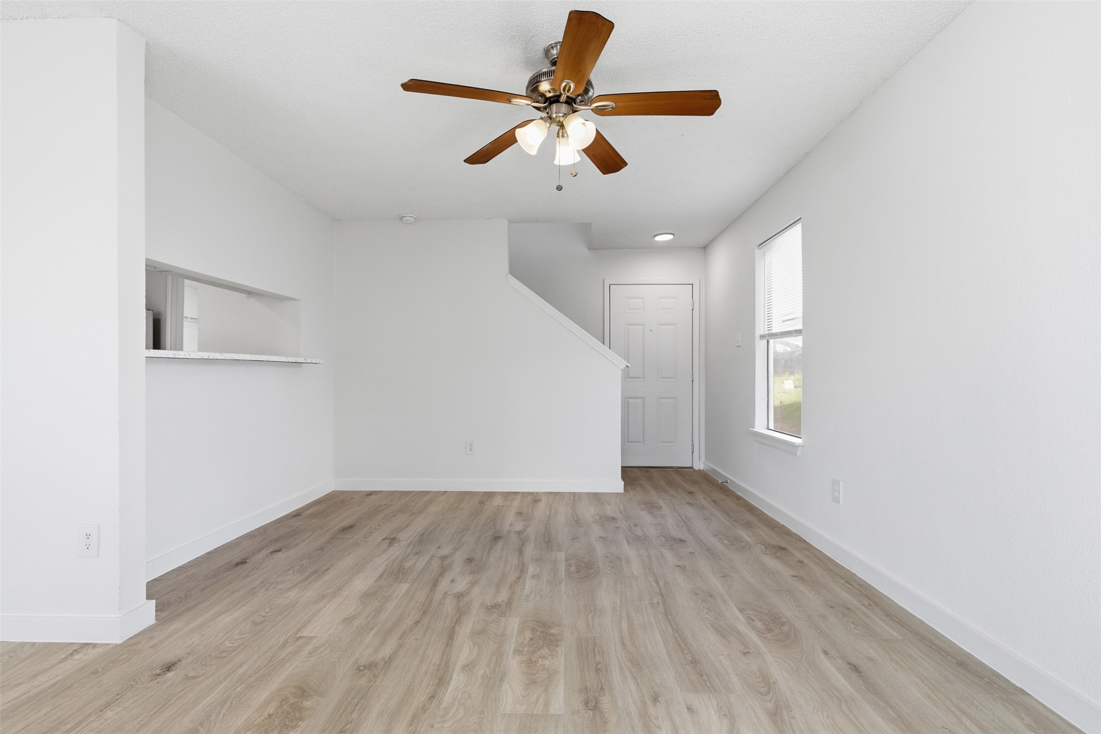 1605 Future Drive, Unit B Austin, TX 78754 - Photo 3 of 13 Unfurnished living room featuring ceiling fan and light wood-style floors