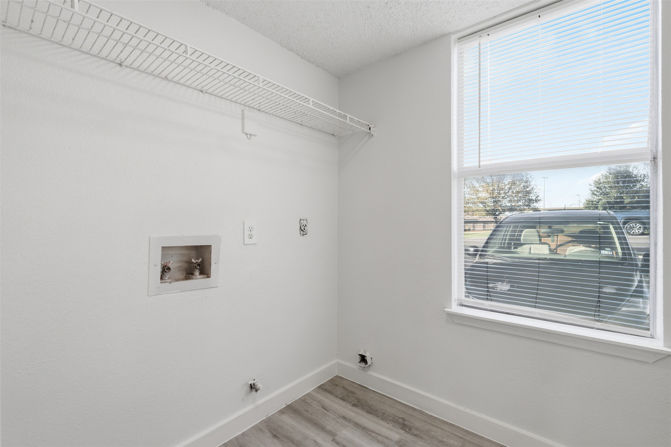 1605 Future Drive, Unit B Austin, TX 78754 - Photo 7 of 13 Laundry area with hookup for a gas dryer, light vinyl floors, hookup for a washing machine, and a textured ceiling