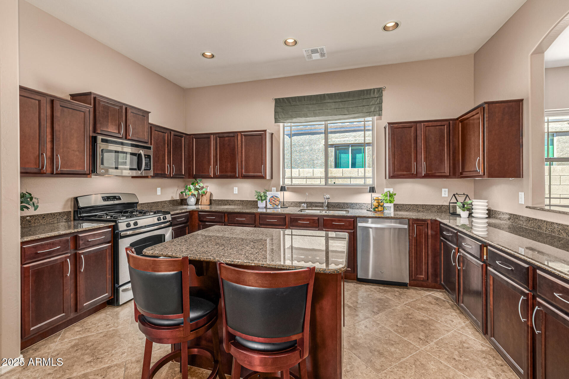 6202 East McKellips Road, Unit 156 Mesa, AZ 85215 - Photo 10 of 57 a kitchen with stainless steel appliances granite countertop a stove top oven a sink dishwasher a dining table and chairs