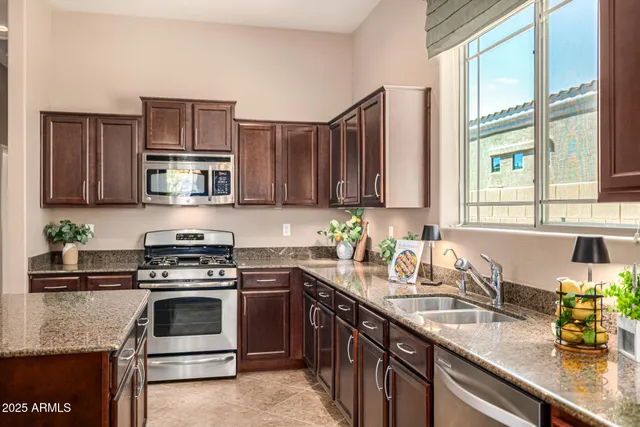 a kitchen with stainless steel appliances granite countertop a sink dishwasher stove and refrigerator