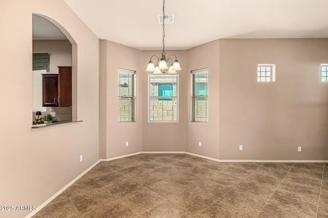 a living room with furniture a chandelier and a dining table