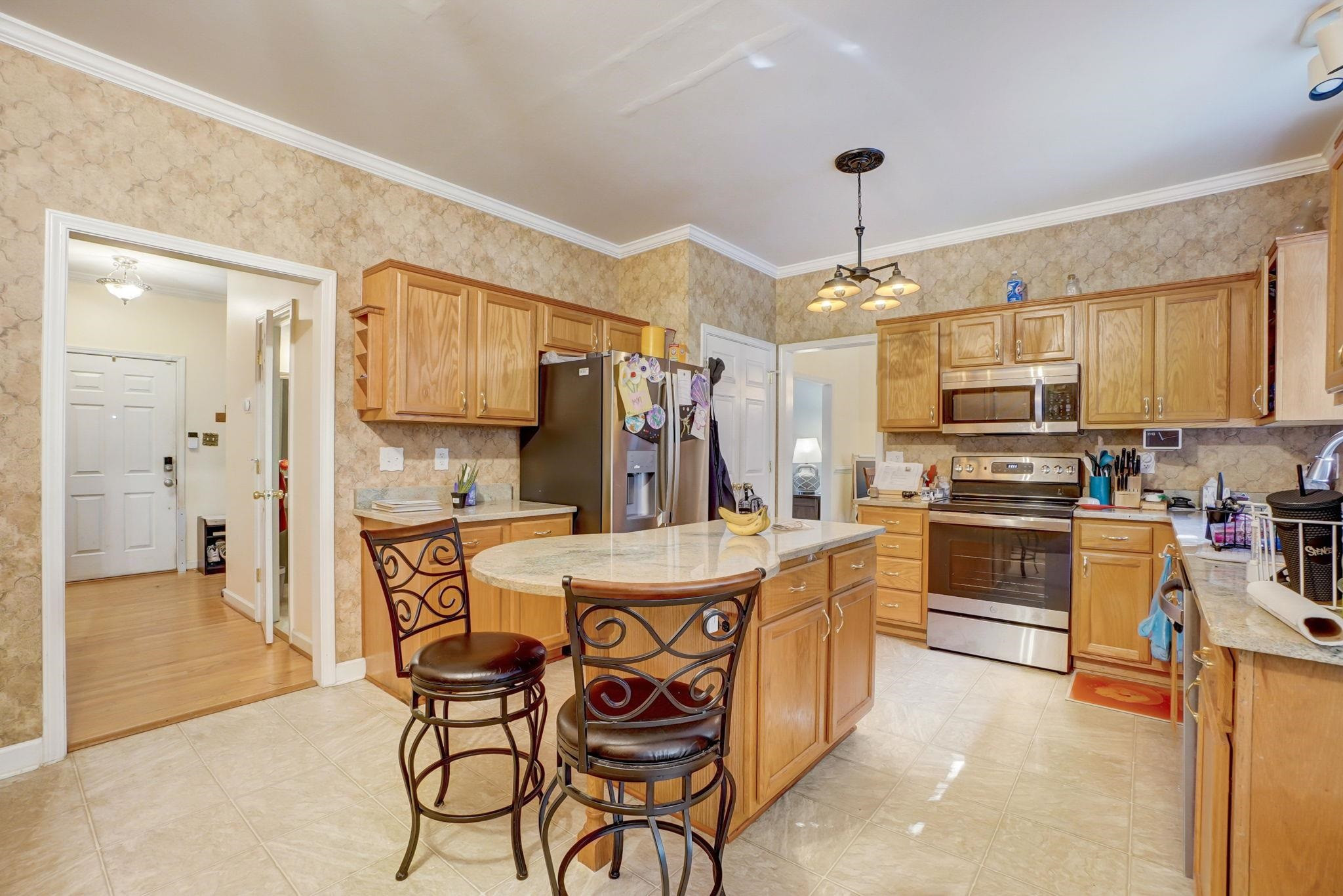 4816 Elmhurst Ridge Court Raleigh, NC 27616 - Photo 6 of 27 a kitchen with a refrigerator a stove top oven a sink dishwasher and white cabinets with wooden floor