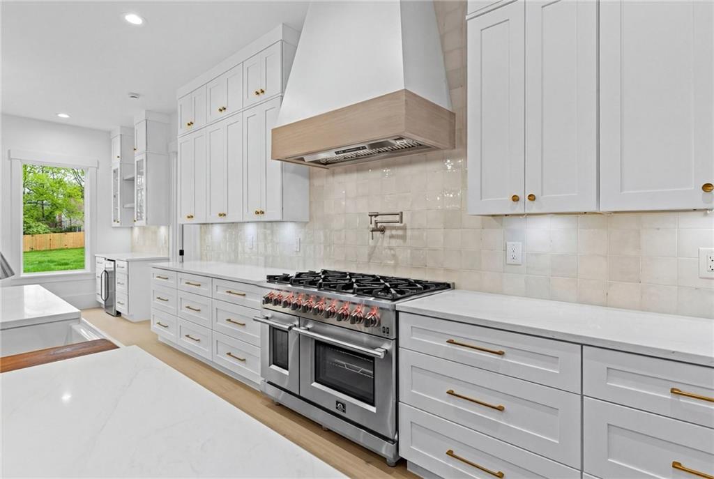 2865 Old Fountain Road Dacula, GA 30019 - Photo 15 of 84 a kitchen with granite countertop white cabinets and stainless steel appliances