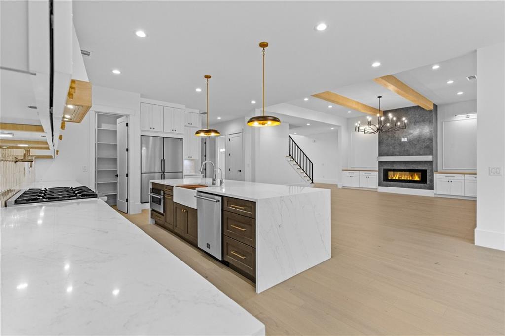 2865 Old Fountain Road Dacula, GA 30019 - Photo 16 of 84 a large kitchen with stainless steel appliances kitchen island a large counter top a stove and a sink