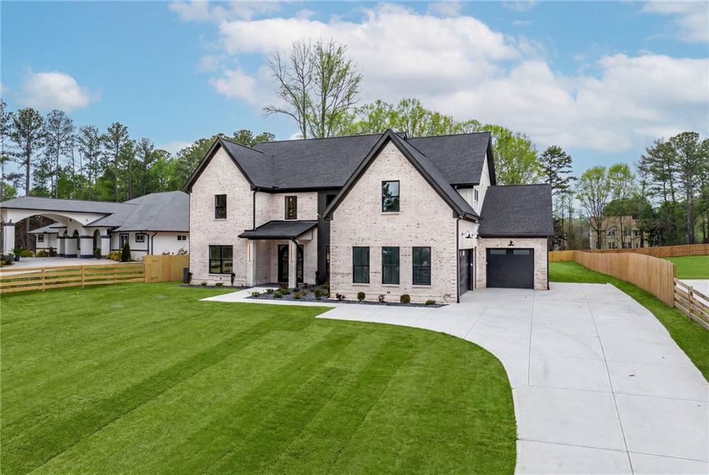 2865 Old Fountain Road Dacula, GA 30019 - Photo 2 of 84 a front view of a house with a garden and yard