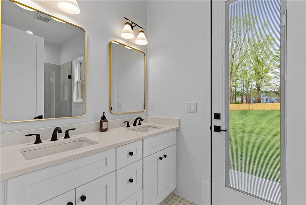 2865 Old Fountain Road Dacula, GA 30019 - Photo 45 of 84 a bathroom with a double vanity sink and mirror with bathtub