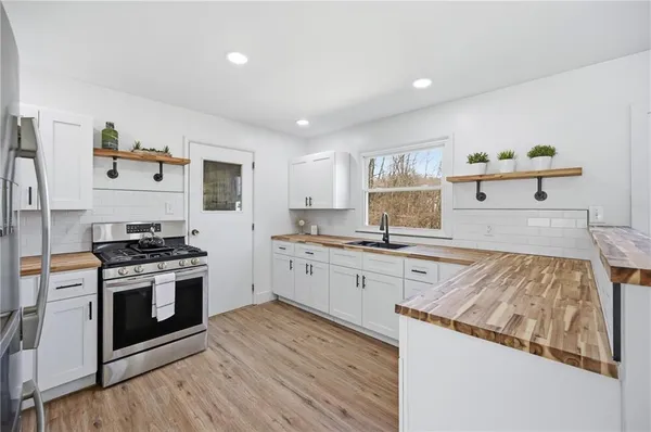a kitchen with granite countertop wooden floors and stainless steel appliances