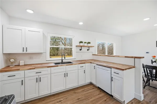 a kitchen with white cabinets and sink