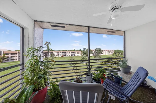 a living room with patio furniture and a floor to ceiling window
