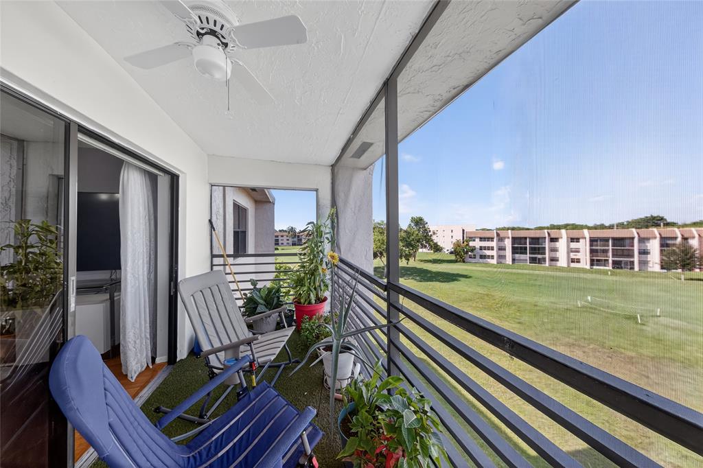 10145 Sunrise Lakes Boulevard, Unit 406 Sunrise, FL 33322 - Photo 13 of 37 a view of a balcony with chairs and potted plants