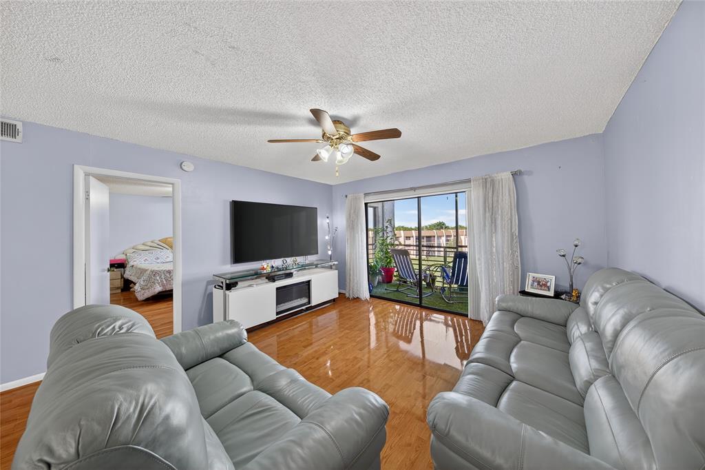 10145 Sunrise Lakes Boulevard, Unit 406 Sunrise, FL 33322 - Photo 16 of 37 a living room with furniture and a flat screen tv