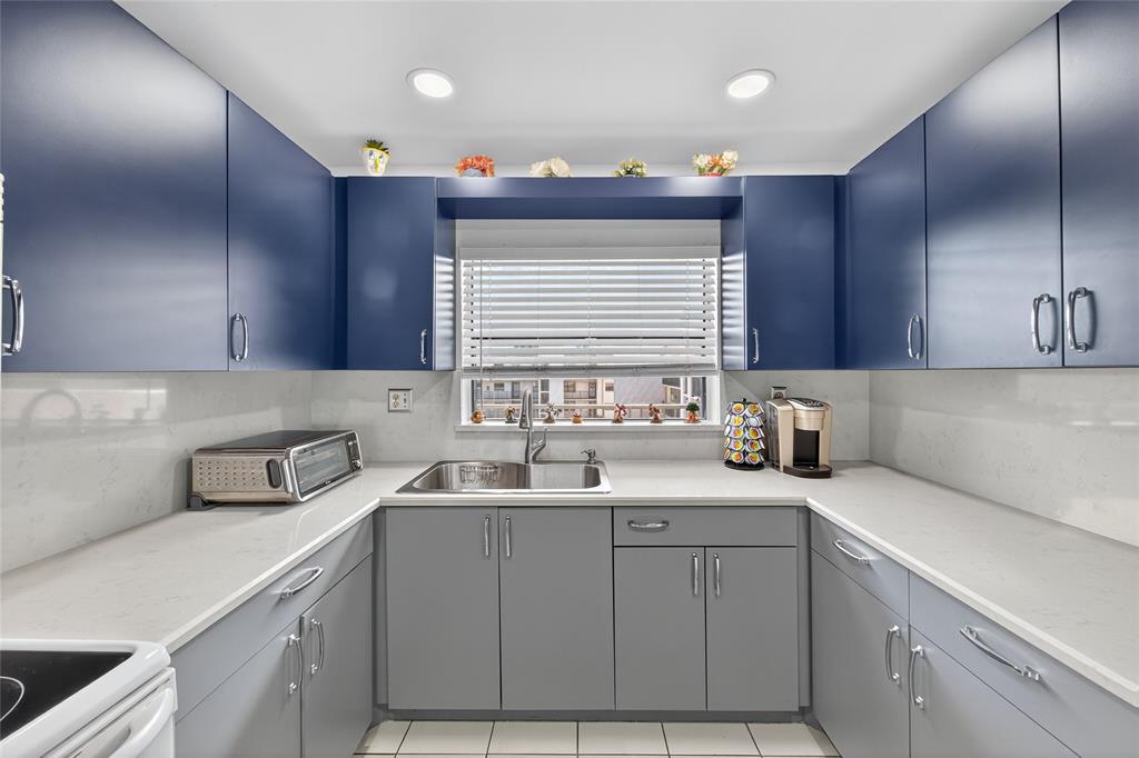 10145 Sunrise Lakes Boulevard, Unit 406 Sunrise, FL 33322 - Photo 20 of 37 a kitchen with a sink cabinets and window