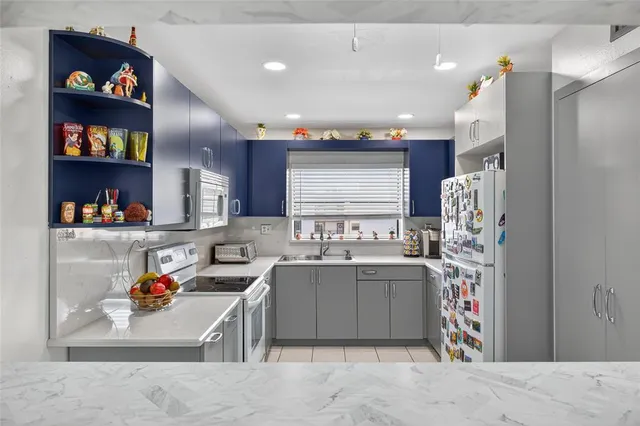 a kitchen with stainless steel appliances granite countertop a sink dishwasher stove and cabinets