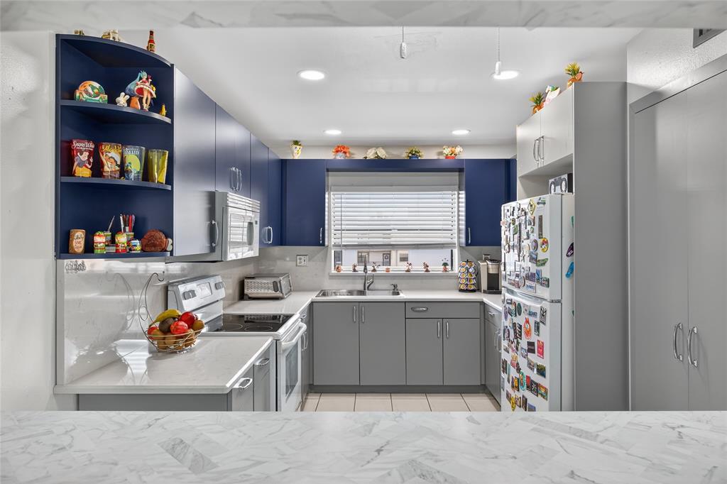 10145 Sunrise Lakes Boulevard, Unit 406 Sunrise, FL 33322 - Photo 21 of 37 a kitchen with stainless steel appliances granite countertop a sink dishwasher stove and cabinets