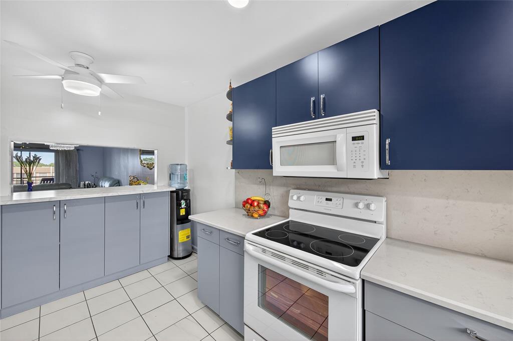 10145 Sunrise Lakes Boulevard, Unit 406 Sunrise, FL 33322 - Photo 22 of 37 a kitchen with a stove and a microwave