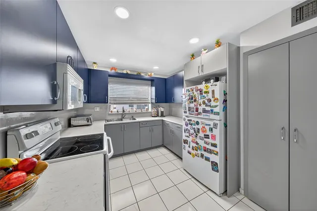 a kitchen with a sink refrigerator and cabinets