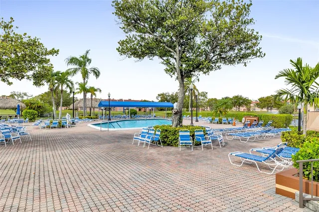 a row of palm trees and a fire pit with large trees