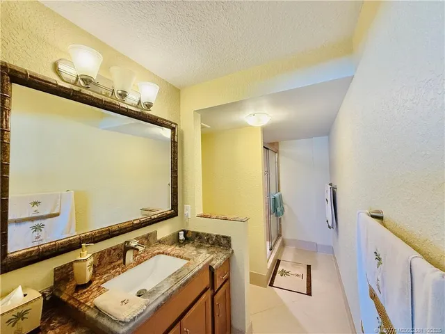 a bathroom with a granite countertop sink mirror vanity and toilet