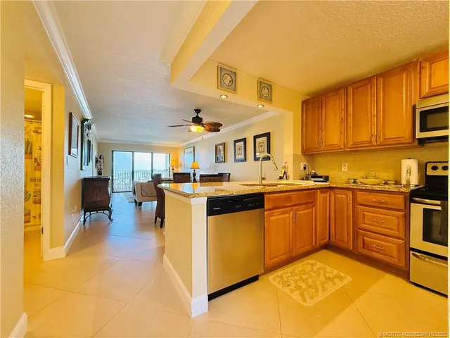 a large kitchen with stainless steel appliances granite countertop a stove refrigerator and a sink