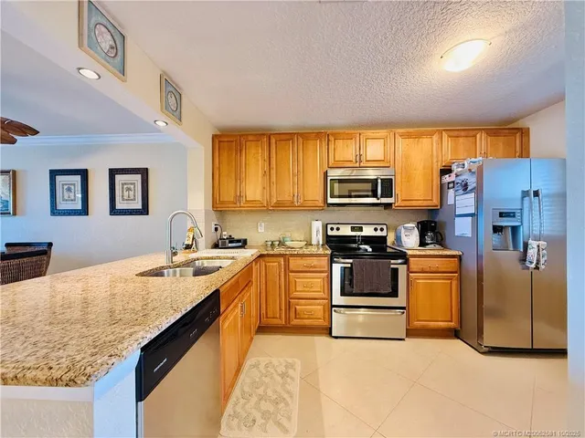 a kitchen with stainless steel appliances granite countertop a stove and a refrigerator