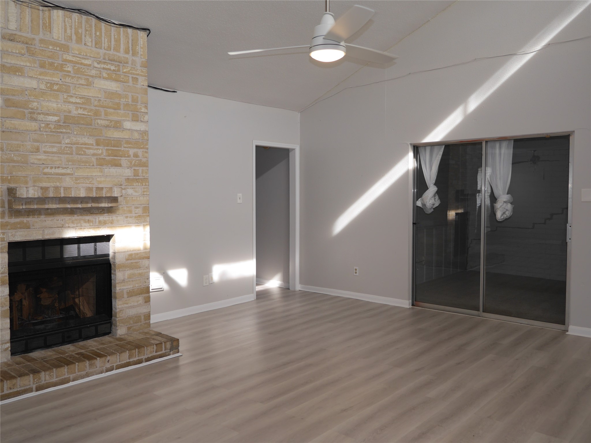 7410 Canasta Lane Houston, TX 77083 - Photo 16 of 33 an empty room with wooden floor fireplace and windows