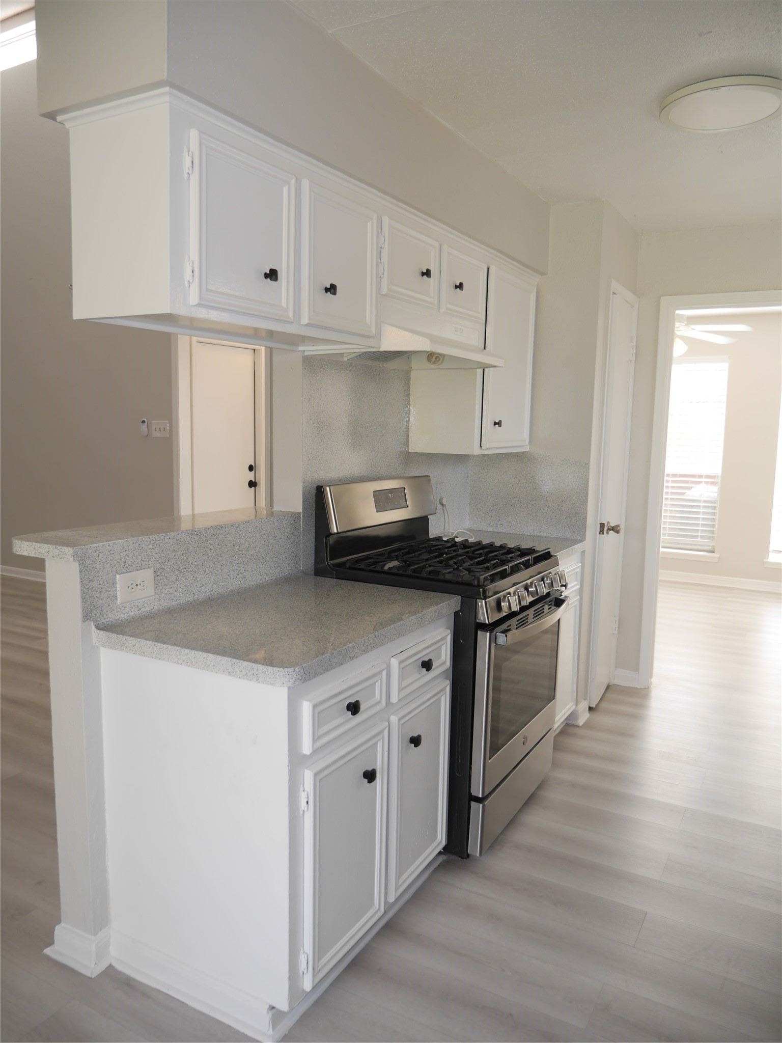 7410 Canasta Lane Houston, TX 77083 - Photo 7 of 33 a kitchen with granite countertop a stove and a white cabinets