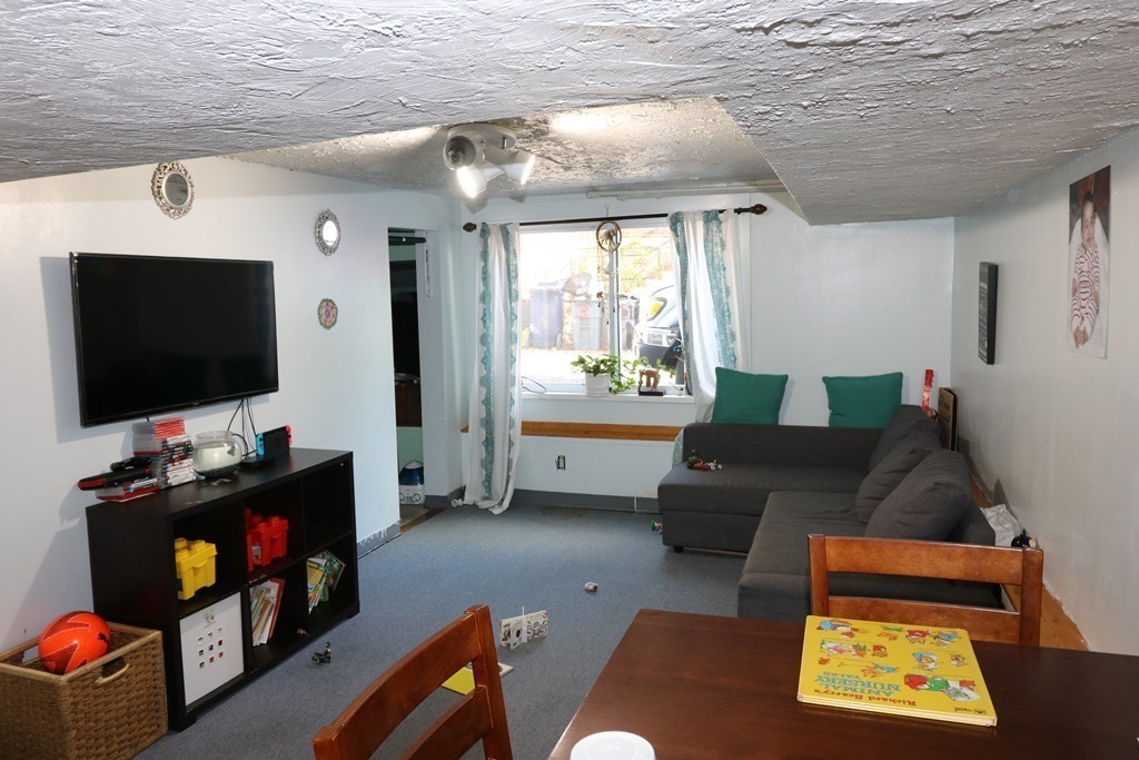 9 Whitby Street Boston, MA 02128 - Photo 13 of 15 a living room with furniture and a flat screen tv